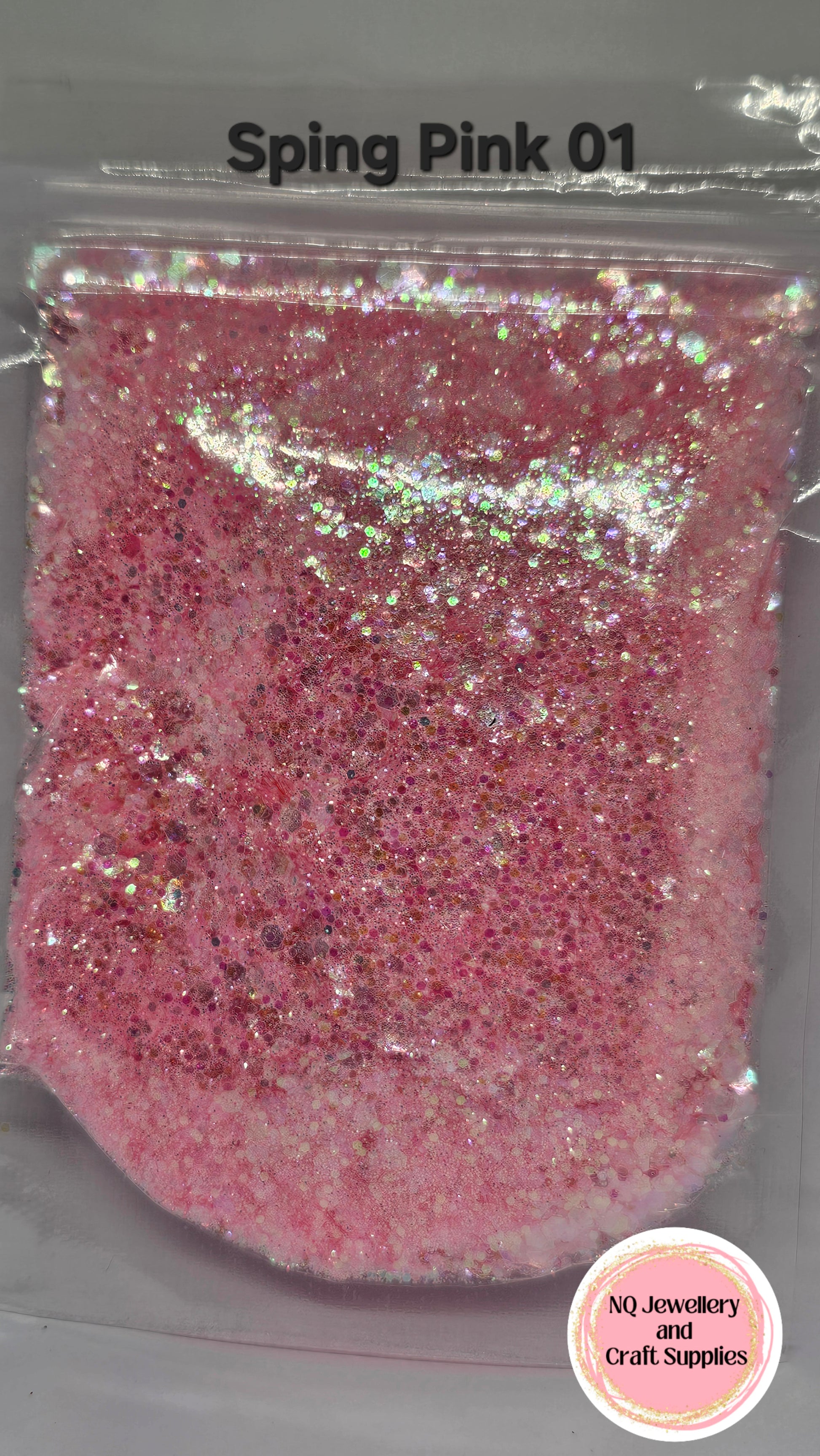 Pink glitter in a clear plastic bag with 'NQ Jewelry and Craft Supplies' branding.